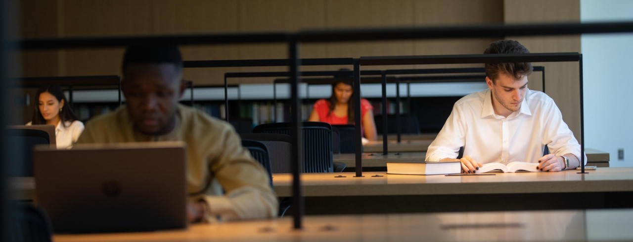 students sitting at tables studying in the law library